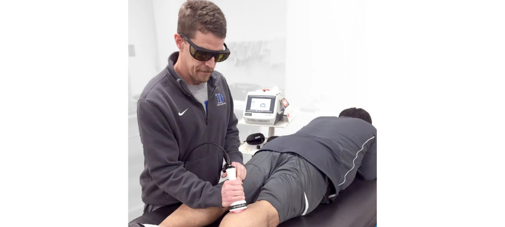 man using laser on back of knee
