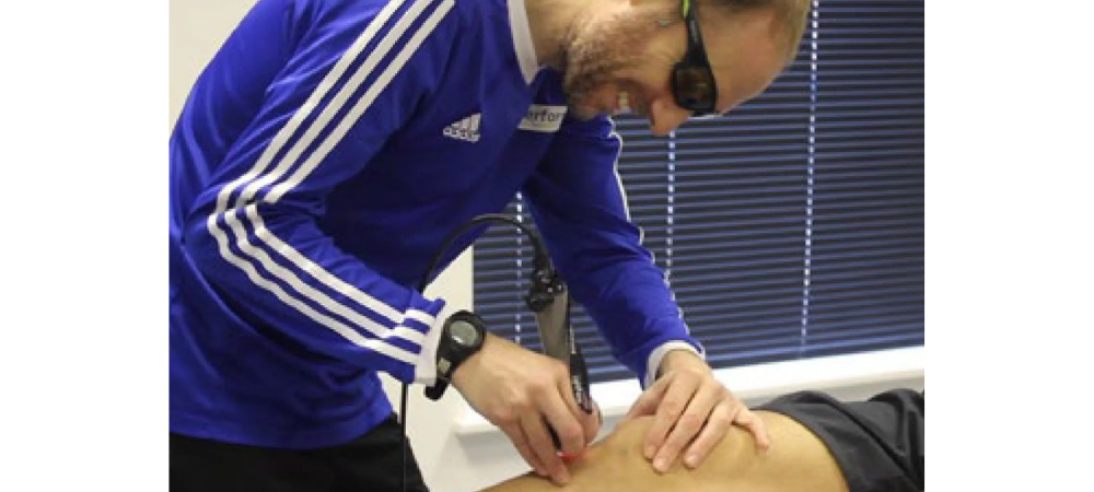 clinician using laser on patient knee