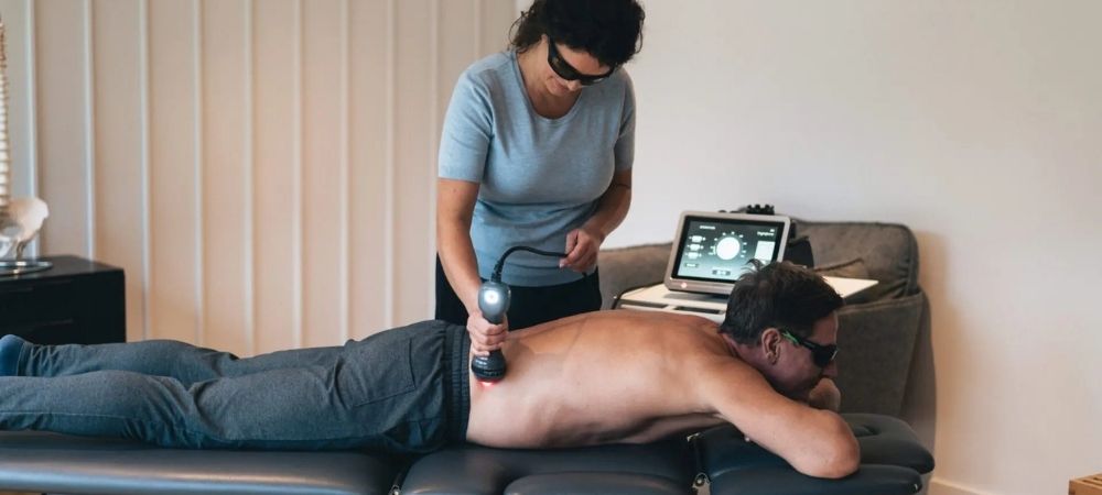 clinician applying laser to patient lower back