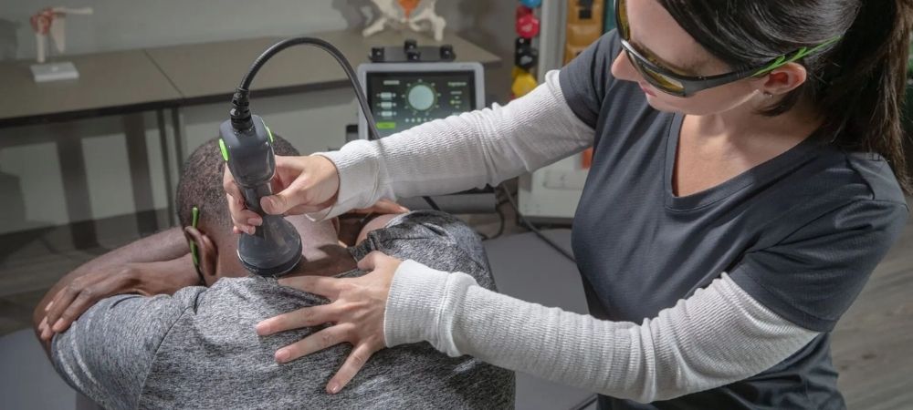 clinician applying laser to patient neck