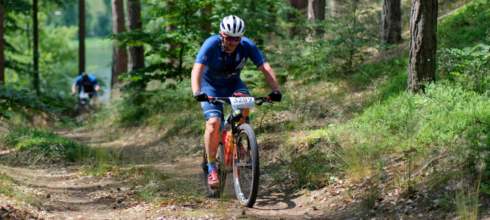 man riding bike through forest