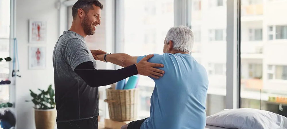 physical therapist assessing shoulder range of motion for an elderly patient