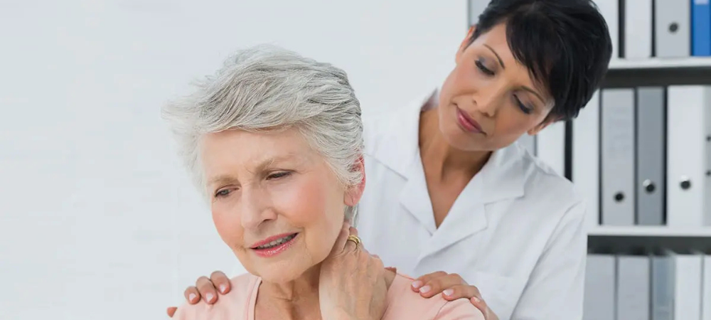 elderly woman with neck pain, doctor standing behind her